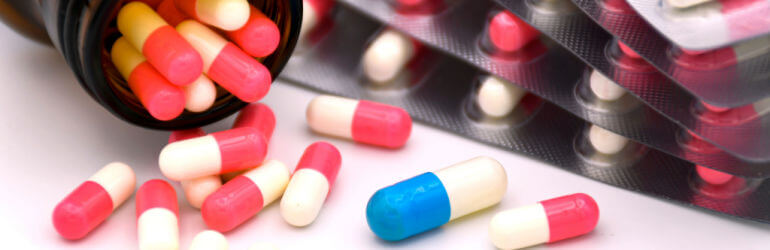 Prescription medication capsules spilling from a bottle, symbolizing medication errors and the risks of prescription mistakes in Greensboro, NC.