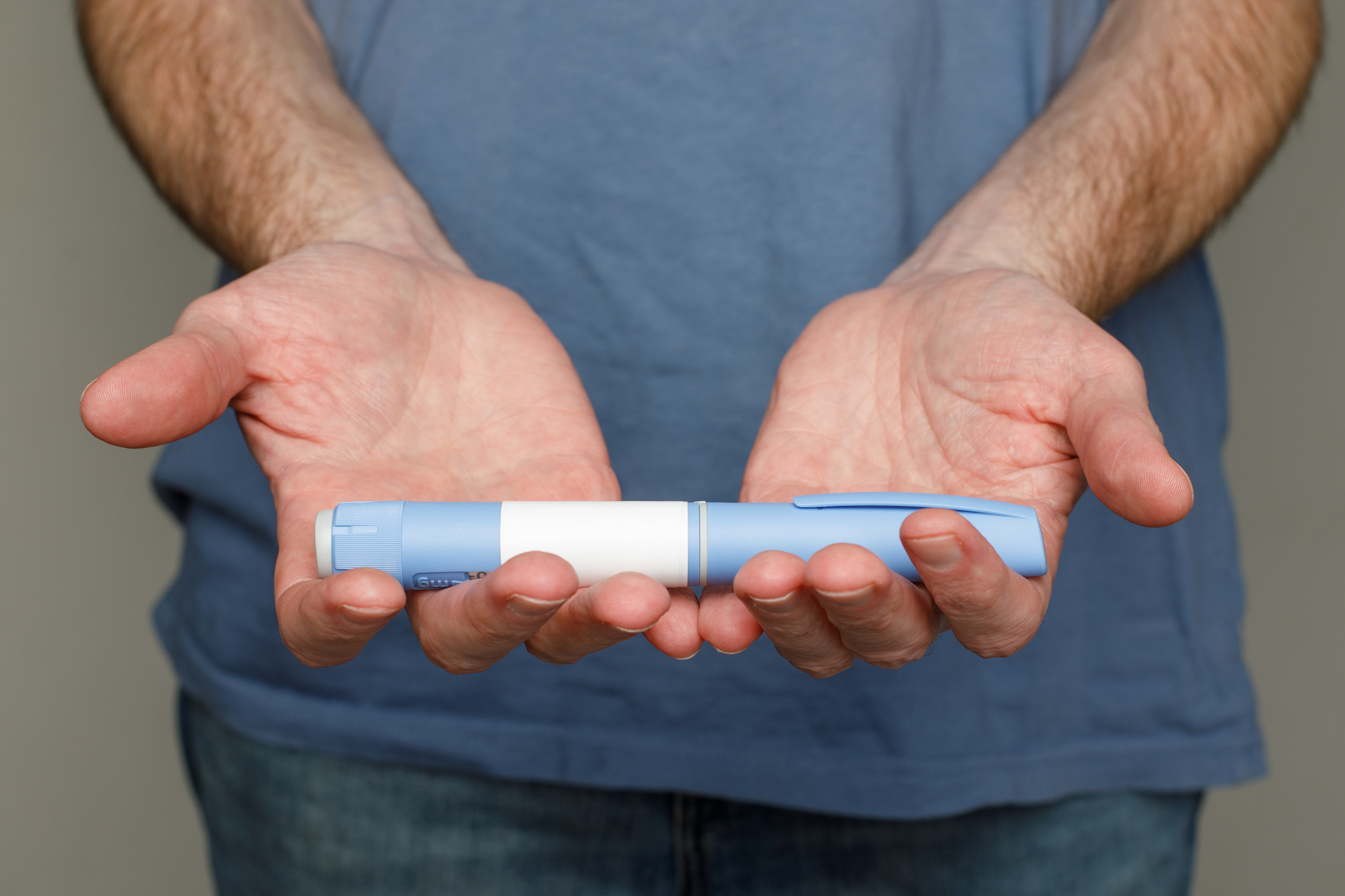 Man holding blue injection pen