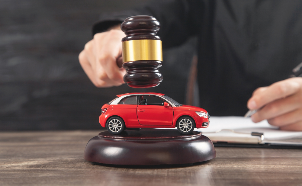 Gavel striking near toy car representing North Carolina car accident attorney handling legal claims